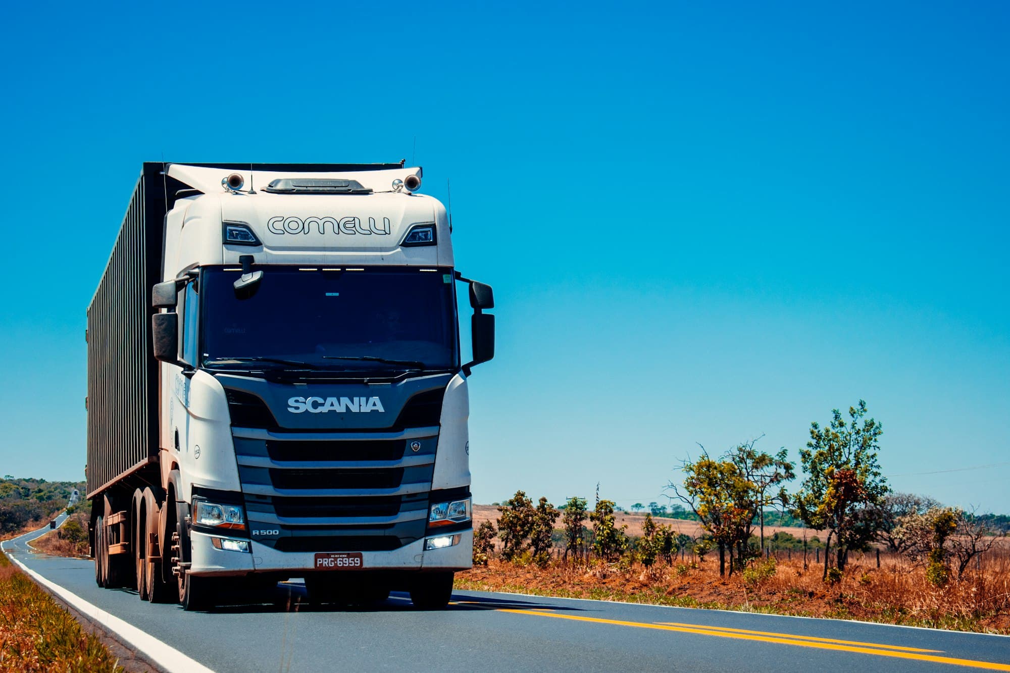 Tractocamión azul circulando por una carretera de México durante la hora dorada.